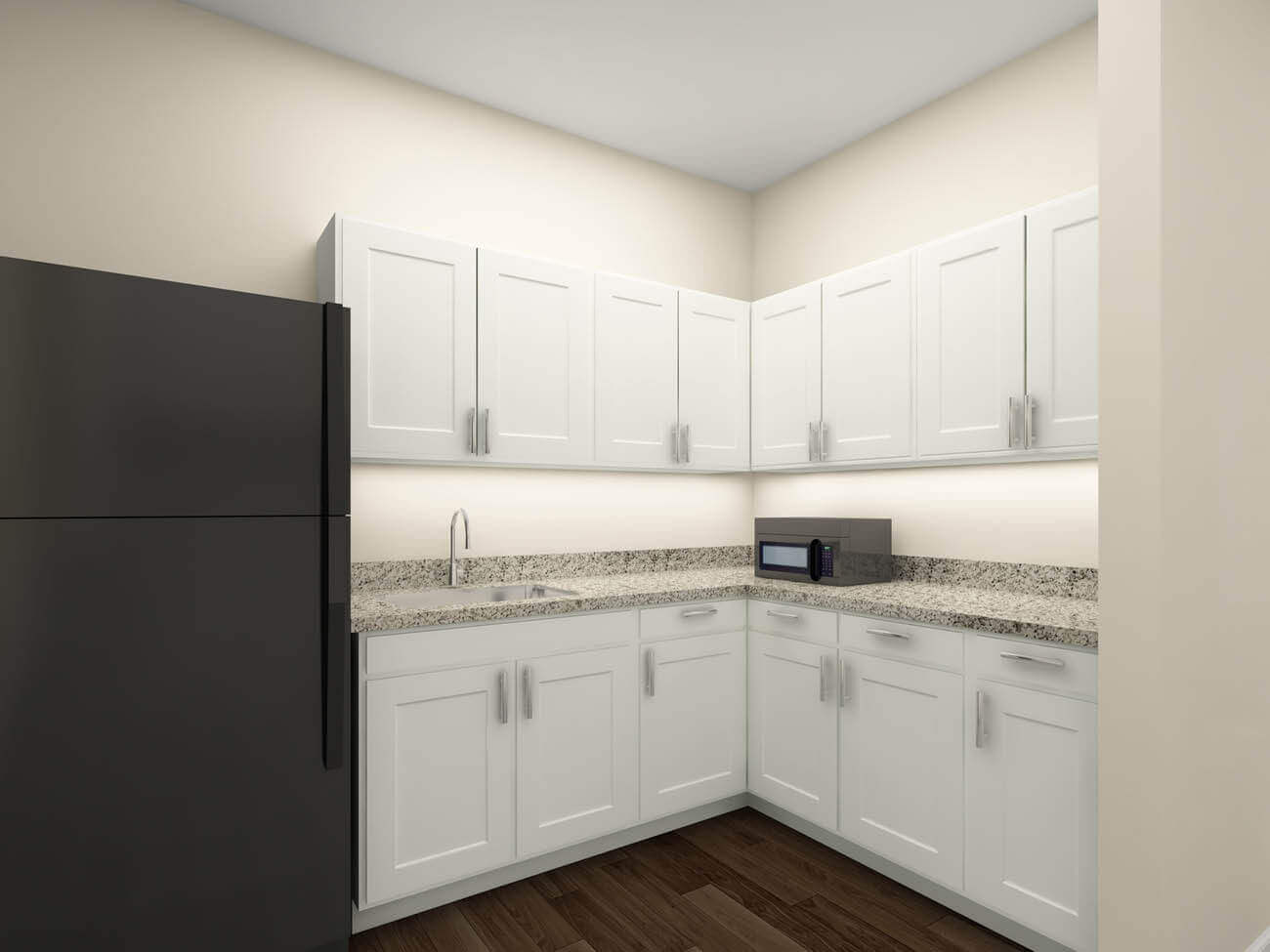 kitchenette with white cabinets and a black fridge