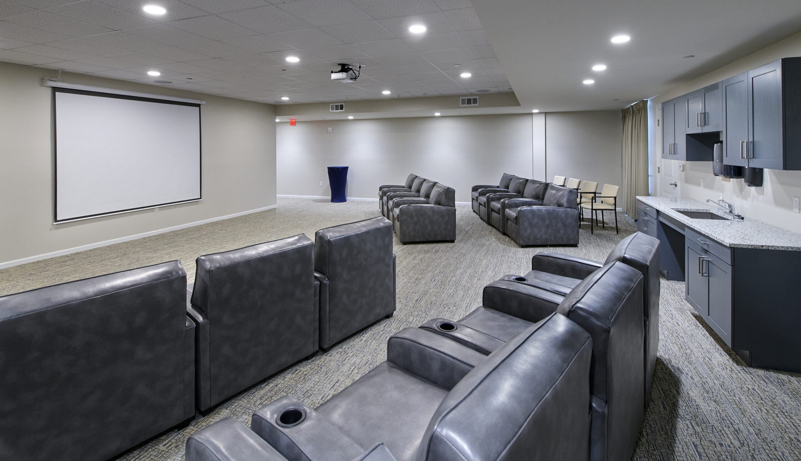 movie theater room with large gray, oversized upholstered seats