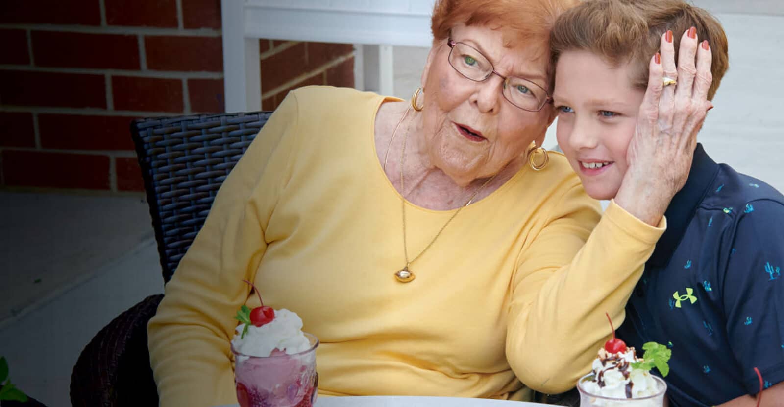 grandmother and grandson having ice cream sundaes