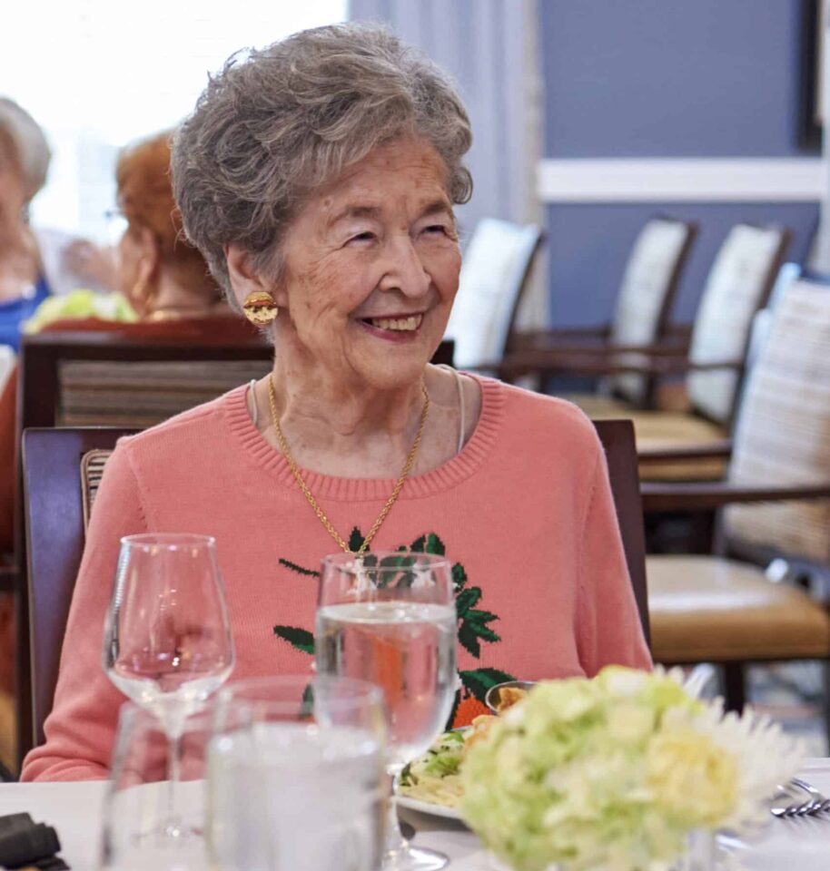 woman laughing while dining