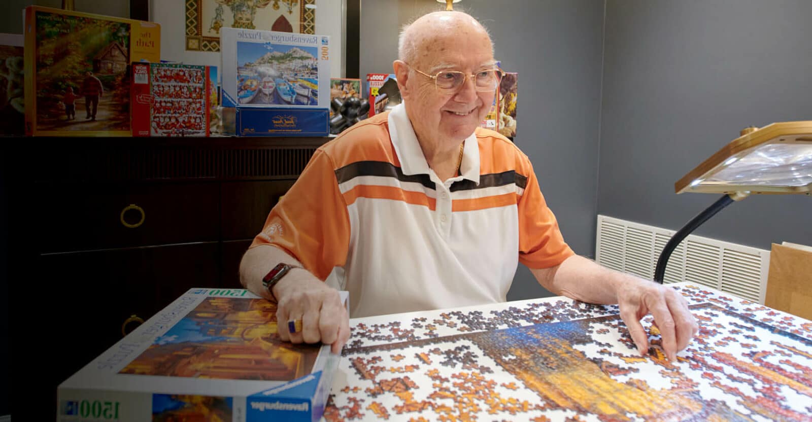 man working on a jigsaw puzzle at a table